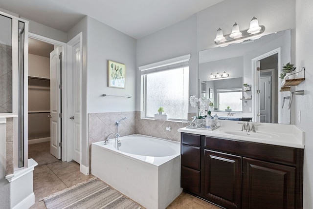 7817 Aria Loop, Austin, TX 78736 - bathroom with vanity, a garden tub, tile patterned flooring, and a walk in closet