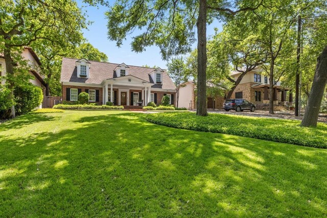 1307 Elton Ln, Austin, TX 78703 - cape cod house with a front lawn, a porch, and brick siding