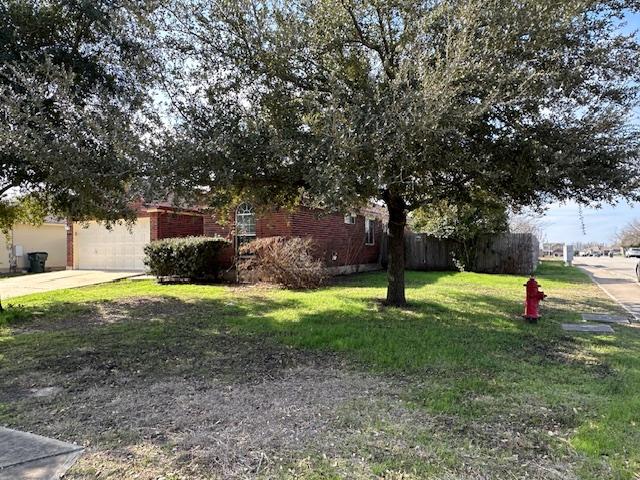 377 Donatello, Kyle, TX 78640 - obstructed view of property with an attached garage, concrete driveway, and a front yard