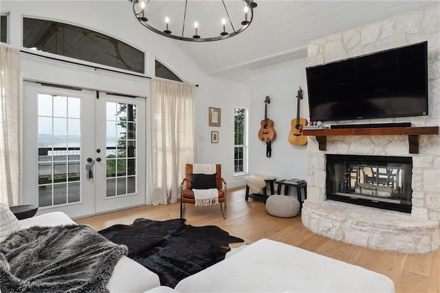 5224 Mccormick Mountain Dr, Austin, TX 78734 - living area with vaulted ceiling, french doors, wood finished floors, a chandelier, and a stone fireplace