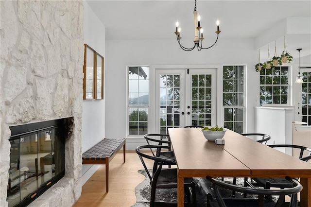 5224 Mccormick Mountain Dr, Austin, TX 78734 - dining space with light wood-type flooring, a chandelier, a fireplace, and french doors