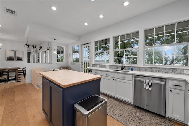 5224 Mccormick Mountain Dr, Austin, TX 78734 - kitchen featuring stainless steel dishwasher, a sink, a kitchen island, white cabinets, and recessed lighting