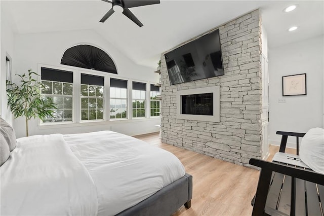 5224 Mccormick Mountain Dr, Austin, TX 78734 - bedroom with vaulted ceiling, wood finished floors, a stone fireplace, ceiling fan, and recessed lighting