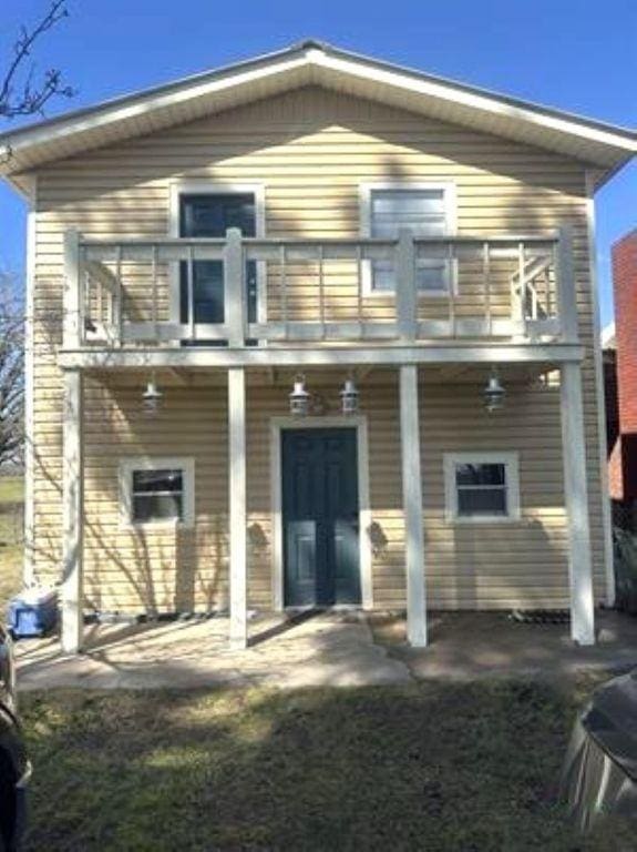 back of property featuring a balcony