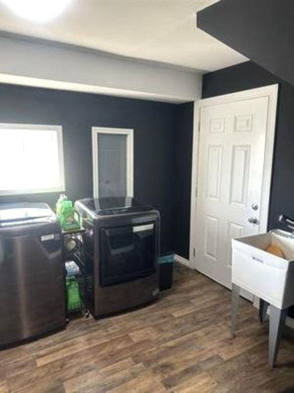 interior space featuring laundry area, wood finished floors, and washer / dryer