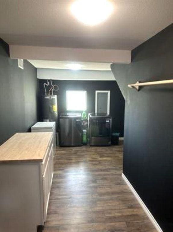 laundry room with washer / dryer, dark wood-style flooring, and water heater