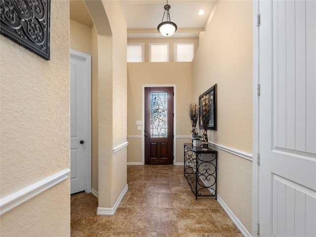 foyer with baseboards and arched walkways