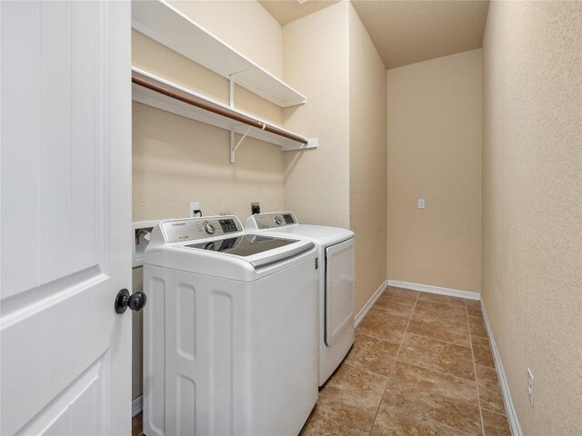 laundry room featuring independent washer and dryer, laundry area, baseboards, and stone finish flooring