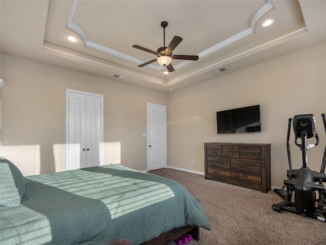 carpeted bedroom with a tray ceiling, baseboards, visible vents, and recessed lighting