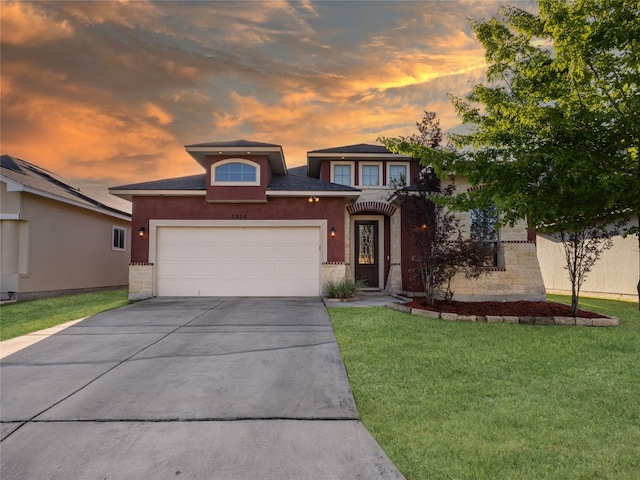 prairie-style home with a front yard, driveway, stucco siding, and an attached garage