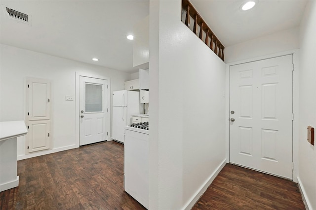 interior space featuring visible vents, light countertops, white appliances, and dark wood finished floors