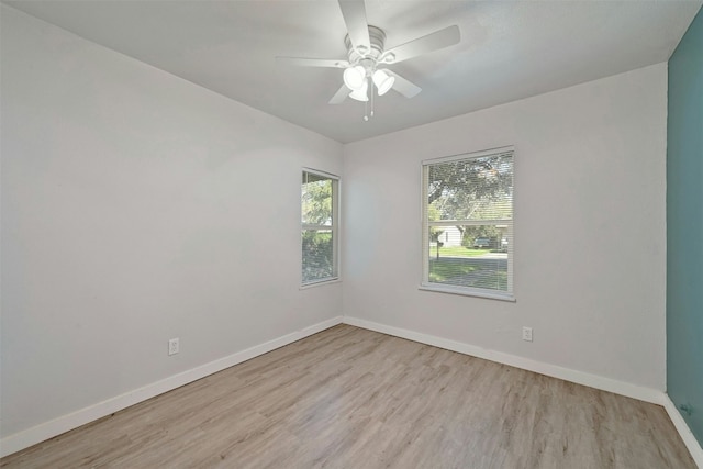 spare room featuring ceiling fan, baseboards, and wood finished floors