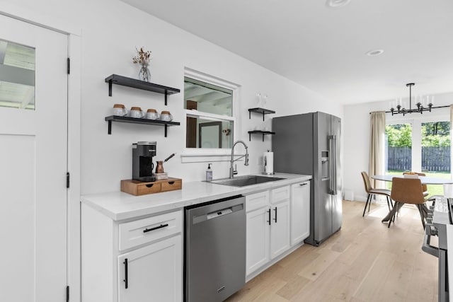 5803 Blythewood Dr, Austin, TX 78745 - kitchen with appliances with stainless steel finishes, a sink, open shelves, a chandelier, and light wood-type flooring