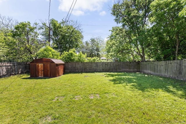 view of yard featuring an outdoor structure, a fenced backyard, and a shed