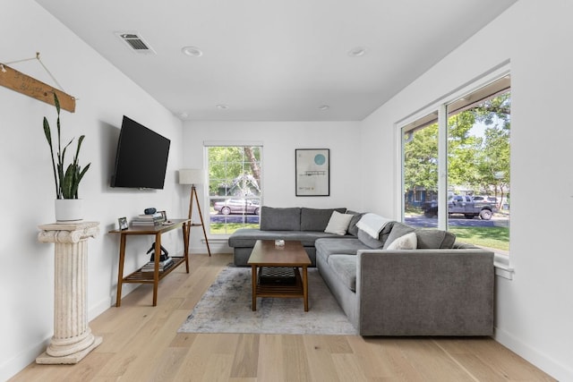 living room featuring recessed lighting, baseboards, light wood-type flooring, and visible vents
