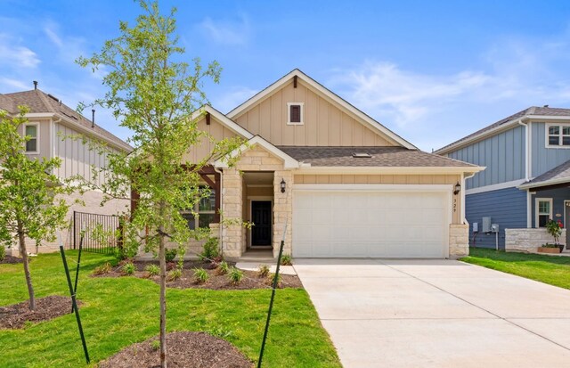329 Singing Dove Way, Liberty Hill, TX 78642 - craftsman-style home with board and batten siding, stone siding, an attached garage, concrete driveway, and a shingled roof