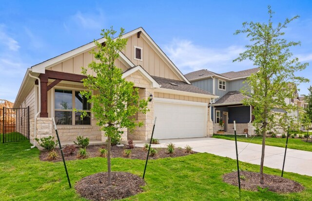 329 Singing Dove Way, Liberty Hill, TX 78642 - craftsman house with board and batten siding, concrete driveway, an attached garage, and stone siding