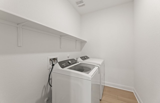 329 Singing Dove Way, Liberty Hill, TX 78642 - laundry room with washer and dryer and light wood finished floors