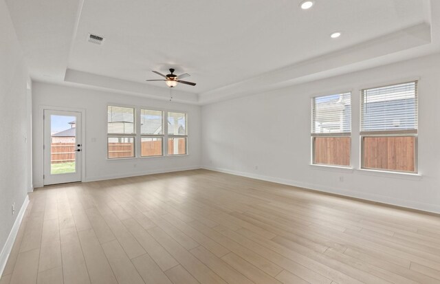 329 Singing Dove Way, Liberty Hill, TX 78642 - unfurnished room with a tray ceiling, ceiling fan, light wood-type flooring, baseboards, and recessed lighting