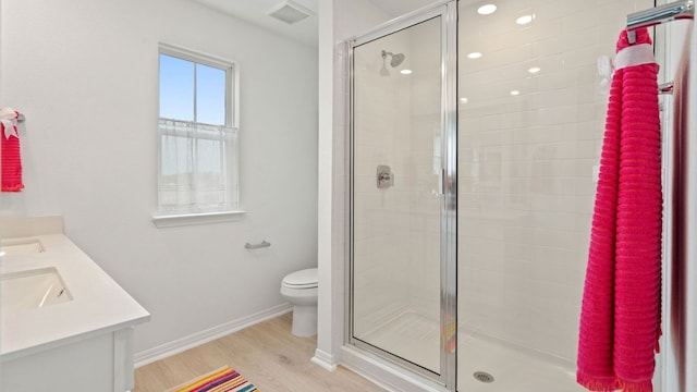 2634 Caleb Asher Loop, Round Rock, TX 78665 - bathroom with double vanity, a shower stall, wood finished floors, baseboards, and toilet