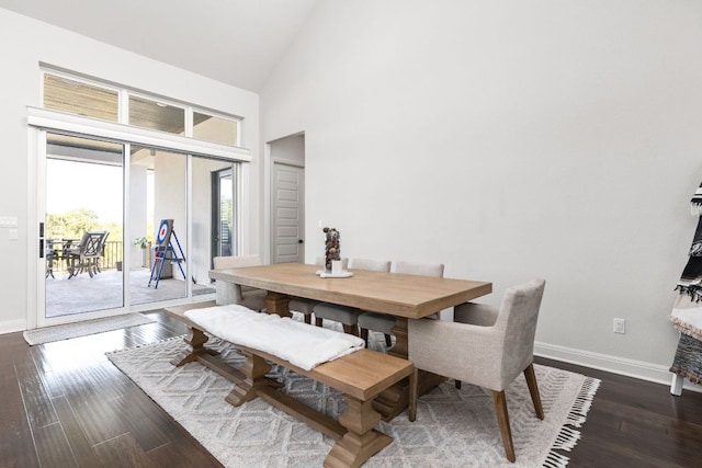 dining room featuring baseboards, high vaulted ceiling, and wood finished floors