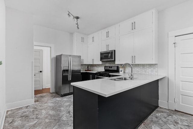 207 W 39th St, Austin, TX 78751 - kitchen with appliances with stainless steel finishes, light countertops, white cabinetry, decorative backsplash, and a peninsula