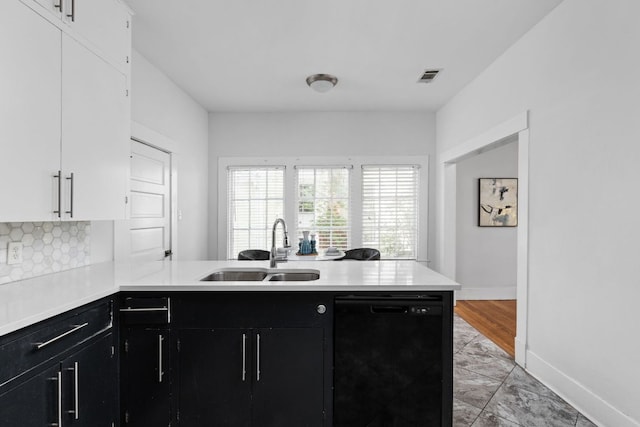 207 W 39th St, Austin, TX 78751 - kitchen with black dishwasher, dark cabinetry, and light countertops