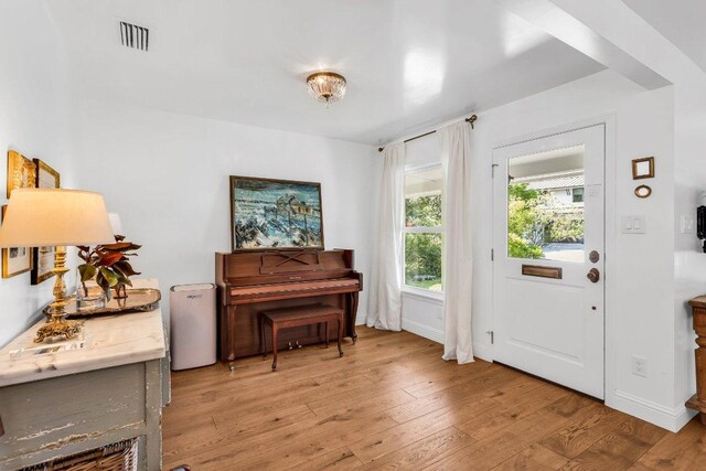 interior space with baseboards, visible vents, and light wood finished floors