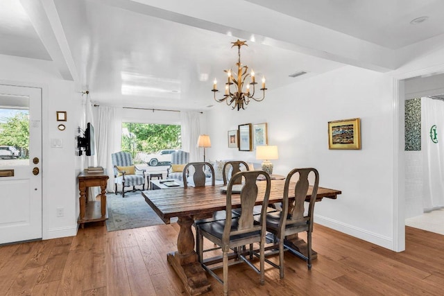 dining space with an inviting chandelier, baseboards, wood-type flooring, and visible vents