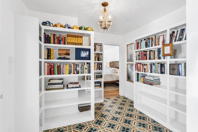 living area with tile patterned floors and a notable chandelier