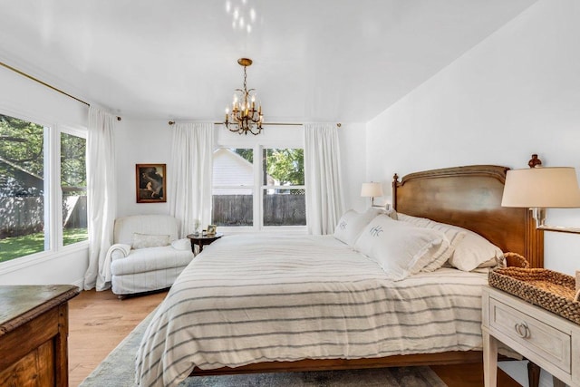bedroom with an inviting chandelier and light wood finished floors