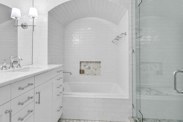 bathroom with vanity, a tile shower, and tiled tub