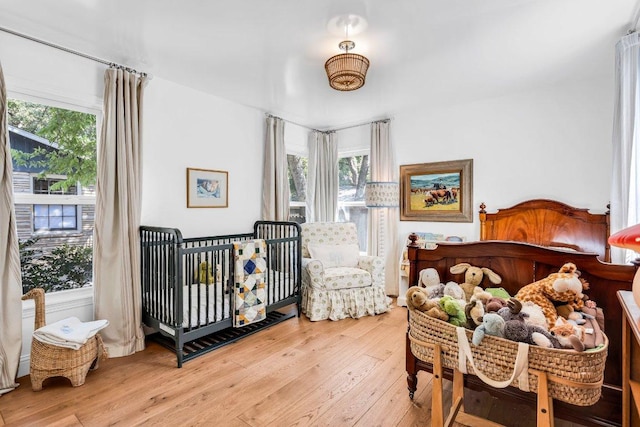 bedroom with light wood-style floors and multiple windows