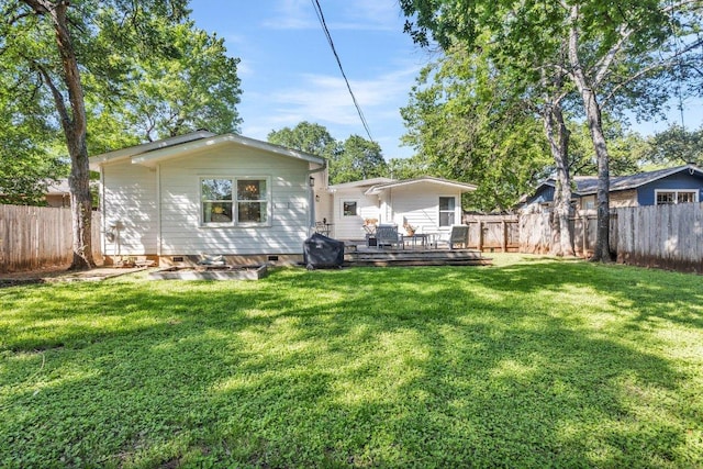 rear view of house featuring a fenced backyard, crawl space, a yard, and a deck