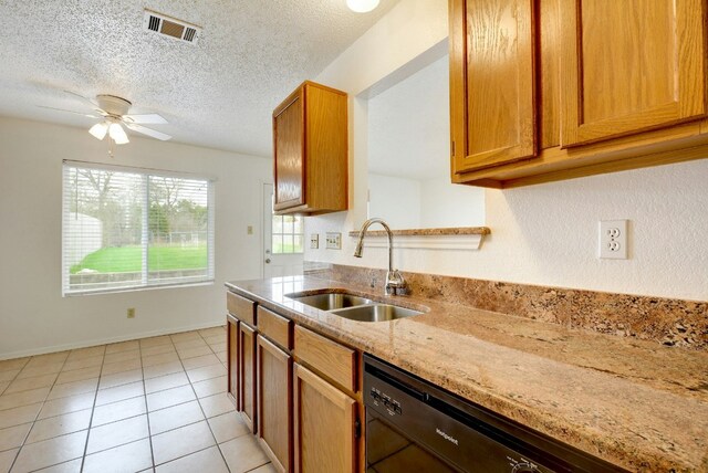 kitchen featuring ceiling fan, light stone countertops, visible vents, black dishwasher, and a sink