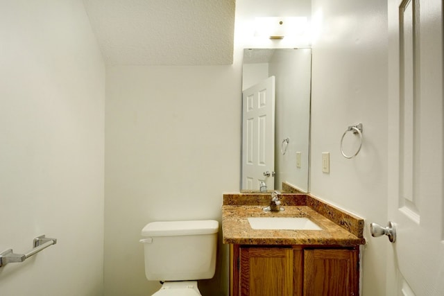 half bath featuring vanity and toilet