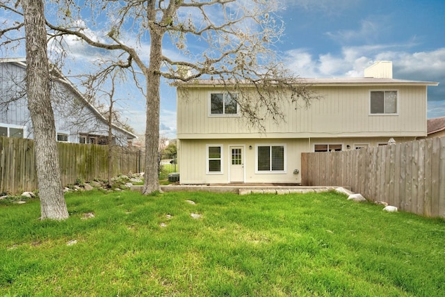 rear view of house featuring a yard, central AC unit, and a fenced backyard