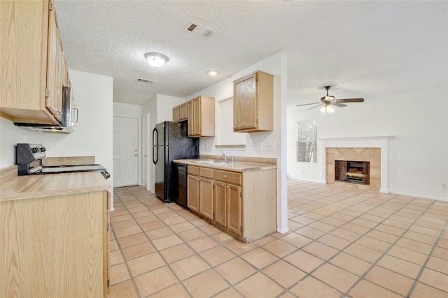 kitchen featuring light tile patterned floors, a ceiling fan, black appliances, light countertops, and open floor plan