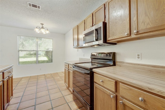 kitchen featuring light countertops, stainless steel microwave, black electric range oven, and visible vents