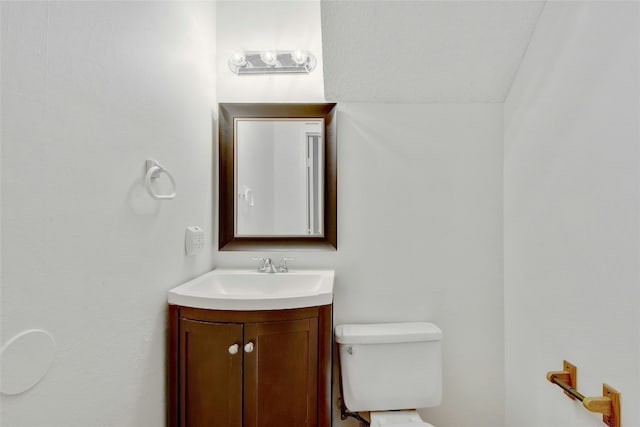 half bath featuring vanity and toilet