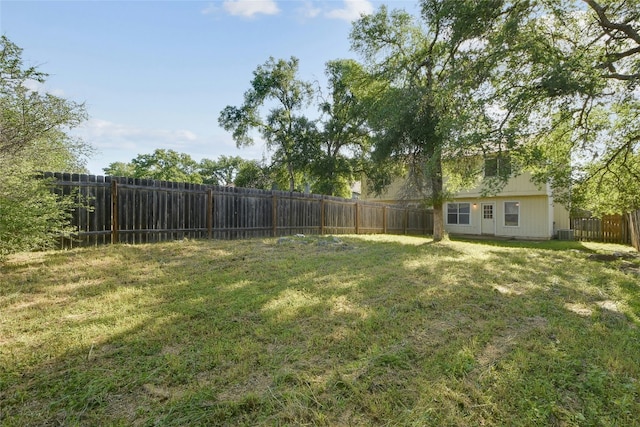 view of yard with central AC unit and a fenced backyard