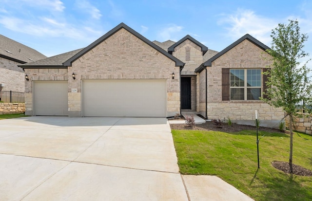 129 Elm View Dr, Georgetown, TX 78628 - view of front of house featuring fence, concrete driveway, an attached garage, stone siding, and a front yard