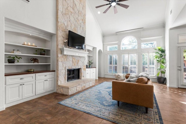 5909 Sunset Rdg, Austin, TX 78735 - living area with high vaulted ceiling, built in shelves, a fireplace, a ceiling fan, and crown molding