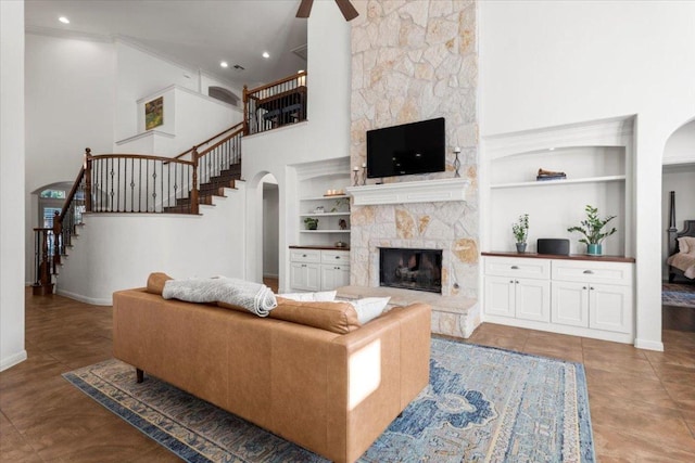 5909 Sunset Rdg, Austin, TX 78735 - living room featuring arched walkways, stairs, built in features, a fireplace, and baseboards