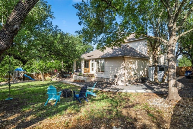 5909 Sunset Rdg, Austin, TX 78735 - back of property with a playground, a fire pit, and a lawn