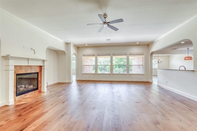 2801 Mirasol Dr, Round Rock, TX 78681 - unfurnished living room with baseboards, wood finished floors, a tiled fireplace, ceiling fan, and ornamental molding