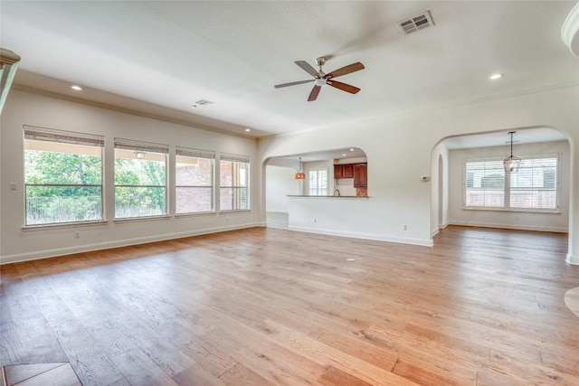 2801 Mirasol Dr, Round Rock, TX 78681 - unfurnished living room featuring arched walkways, a ceiling fan, baseboards, healthy amount of natural light, and recessed lighting
