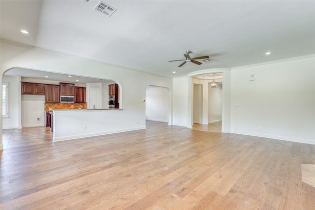 2801 Mirasol Dr, Round Rock, TX 78681 - unfurnished living room featuring arched walkways, a ceiling fan, ornamental molding, recessed lighting, and light wood-style flooring