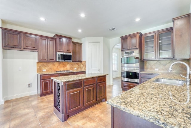 2801 Mirasol Dr, Round Rock, TX 78681 - kitchen with appliances with stainless steel finishes, a sink, arched walkways, baseboards, and recessed lighting