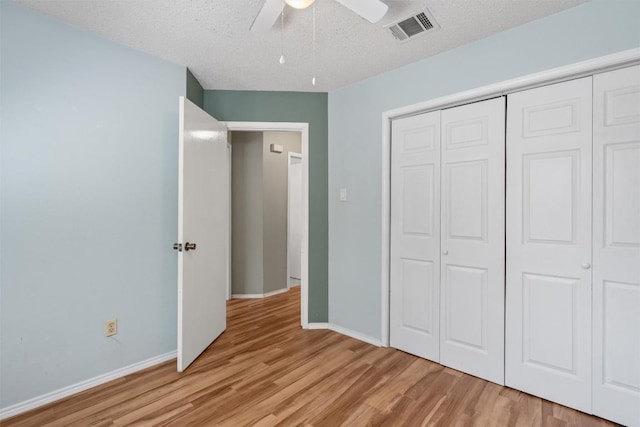 840 Eagles Way, Leander, TX 78641 - unfurnished bedroom featuring light wood finished floors, a closet, a textured ceiling, and a ceiling fan